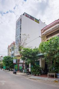 um edifício branco alto com um cartaz em Phú Xuân Hotel em Quy Nhon