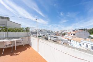 a balcony with a table and a view of a city at Travessa Albufeira Apartments by Umbral in Albufeira