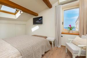 1 dormitorio con cama y ventana en Exclusive Seafront Bacchus Apartment, en Poreč