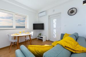 uma sala de estar com um sofá azul e uma mesa em Apartment Seaside em Jesenice