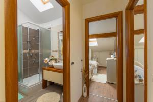 y baño con ducha, lavabo y espejo. en Exclusive Seafront Bacchus Apartment, en Poreč