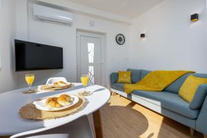 uma sala de estar com um sofá e uma mesa com comida em Apartment Seaside em Jesenice