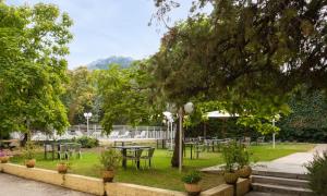 a park with tables and chairs under a tree at Appart Hotel Corte HR in Corte