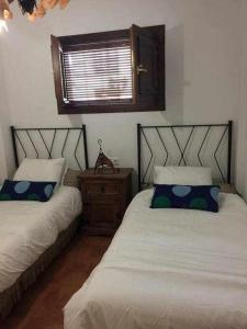 a bedroom with two beds and a window at Apartamento Casa Valero in Rubielos de Mora