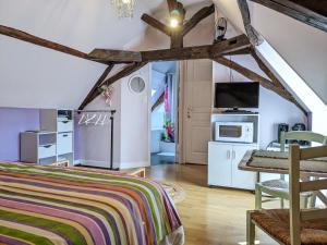 a bedroom with a bed and a table and a kitchen at La Borie du Chevrier in Sainte-Croix-de-Beaumont