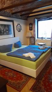 ein Schlafzimmer mit einem großen Bett in einem Zimmer mit einem Fenster in der Unterkunft Pension Alte Schmiede in Greifswald