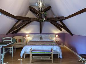 a bedroom with purple walls and a bed with a chandelier at La Borie du Chevrier in Sainte-Croix-de-Beaumont