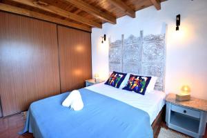a bedroom with a blue bed with two pillows at Casa Coriska in Algoz
