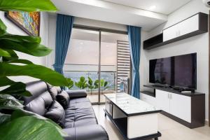 ein Wohnzimmer mit einem Sofa und einem TV in der Unterkunft River Panorama 2Bedroom*Kingbed*Infinity Pool in Ho-Chi-Minh-Stadt