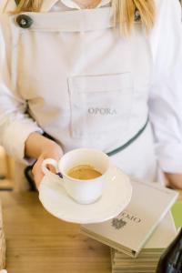 a woman holding a cup of coffee on a plate at Opora Country Living in Nafplio