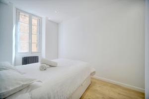カンヌにあるIMMOGROOM -historic center-Fully equipped apartment - AC - Wifiの白いベッドルーム(ベッド1台、窓付)