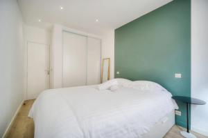 カンヌにあるIMMOGROOM -historic center-Fully equipped apartment - AC - Wifiのベッドルーム1室(白いベッド1台、青い壁付)
