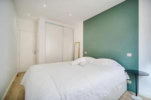 a bedroom with a white bed and a blue wall at IMMOGROOM -historic center-Fully equipped apartment - AC - Wifi in Cannes