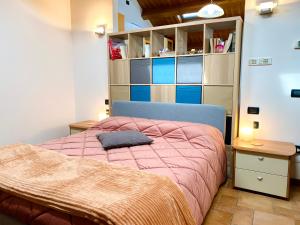 a bedroom with a bed with a pink comforter at SUITE - Alessandra Holiday House in Piove di Sacco