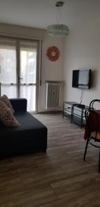salon z kanapą i telewizorem z płaskim ekranem w obiekcie Appartamento San Miguel w mieście Pasian di Prato