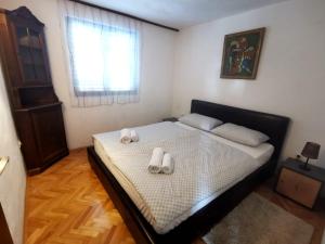 een slaapkamer met een bed met twee slippers erop bij Apartman Sveti Rok in Sveti Rok