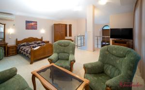 ein Wohnzimmer mit 2 Stühlen und einem Bett in der Unterkunft Hotel Chuchulev in Sozopol
