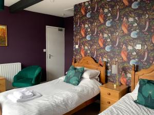 a bedroom with two beds and a colorful wall at Waverley B & B in Minehead