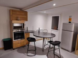 a kitchen with a table and chairs and a refrigerator at Maison calme pour 6 personnes in Mouilleron-le-Captif