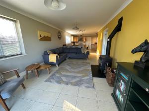 a living room with a blue couch and a table at Llais Y Mor in Carmarthen