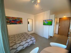 Habitación pequeña con cama y TV. en Clair Soleil, en Balaruc-les-Bains