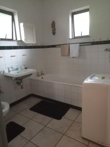a bathroom with a tub and a sink and a toilet at 27@caravenseria in Hibberdene