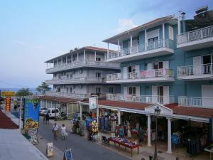 a large building with people walking in front of a street at Rooms Anastasia Paralia in Katerini