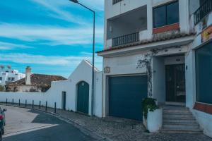 un edificio blanco con puertas azules de garaje en una calle en Apartamento Deluxe Oldtown 30 by Umbral, en Albufeira