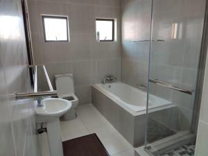 uma casa de banho com uma banheira, um WC e um lavatório. em Coastal Beach Resort em Umkomaas
