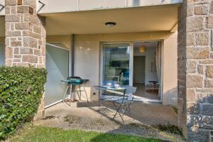 patio z 2 krzesłami i stołem obok budynku w obiekcie À 400m de la mer appartement avec terrasse pour 2 w mieście Fouesnant +5 zdjęć