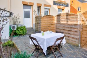 a table with a white table cloth on a patio at À 600m de la plage, maison pour 6 avec terrasse in Le Guilvinec