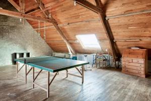 a ping pong table in a room with wooden ceilings at À 600m de la plage, maison pour 6 avec terrasse in Le Guilvinec
