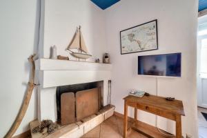 uma sala de estar com uma lareira e uma mesa em Jolie Maison à Noirmoutier-en-ile pour 4 personnes em Noirmoutier-en-l'lle