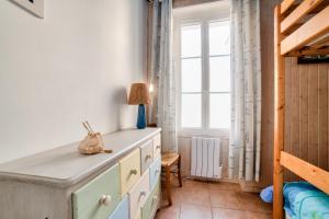 ein Schlafzimmer mit einer Kommode und einem Fenster in der Unterkunft Jolie Maison a Noirmoutier-en-ile pour 4 personnes in Noirmoutier-en-l'lle