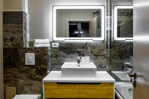a bathroom with a sink and a mirror at ArtHomes Apartments in Timişoara