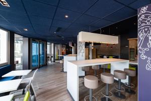 um restaurante com tecto azul e bancos em ibis budget Lyon Villeurbanne em Villeurbanne