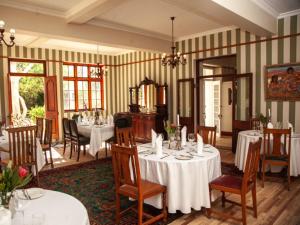 una sala da pranzo con tavoli e sedie in una stanza di Karoo Art Hotel a Barrydale