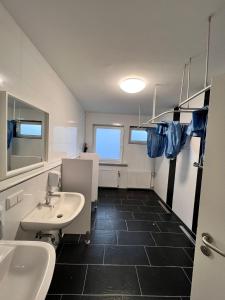 La salle de bains est pourvue de 2 lavabos et de 2 miroirs. dans l'établissement MK Hostel Oyten, à Oyten