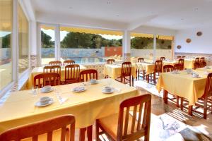 a restaurant with tables and chairs with yellow tablecloths at Zodiaco in Quarteira