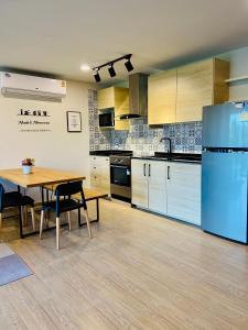 uma cozinha com uma mesa e um frigorífico azul em Bann Chidtha family suite full kitchen near Suvarnabhumi Airport em Banguecoque