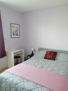 - une chambre avec un lit doté d'un oreiller rouge dans l'établissement Ma Chambre d'Amis, à Auros