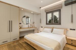 a bedroom with a bed and a mirror at Otium Residence in Kouvaláta