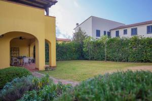 een huis met een tuin met een tafel en stoelen bij Appartamento Barbarossa by HelloElba in Porto Azzurro