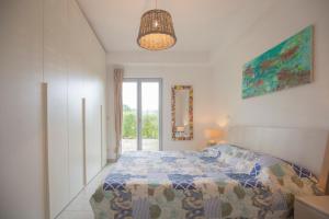 een witte slaapkamer met een bed en een raam bij Appartamento Barbarossa by HelloElba in Porto Azzurro