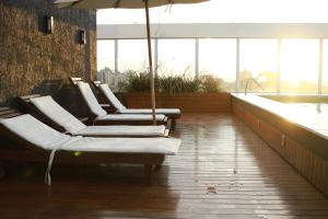 a row of lounge chairs in a room with a tub at Ap no coração de POA in Porto Alegre