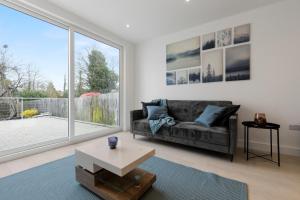 a living room with a couch and a large window at Star London Station Road 2-Bed Retreat with Garden in London