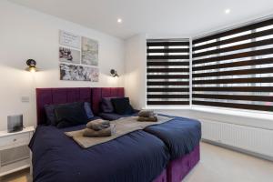 a bedroom with a large bed with two teddy bears on it at Star London Station Road 2-Bed Retreat with Garden in London