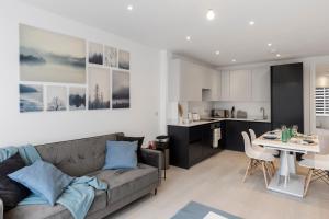 sala de estar y cocina con sofá y mesa en Star London Station Road 2-Bed Retreat with Garden en Londres