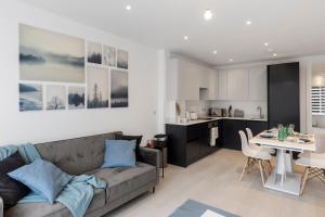 a living room and kitchen with a couch and a table at Star London Station Road 2-Bed Retreat with Garden in London
