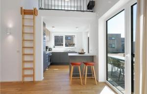 a kitchen with a counter and two stools in front of a table at Nice Home In Lembruchdümmer See in Lembruch